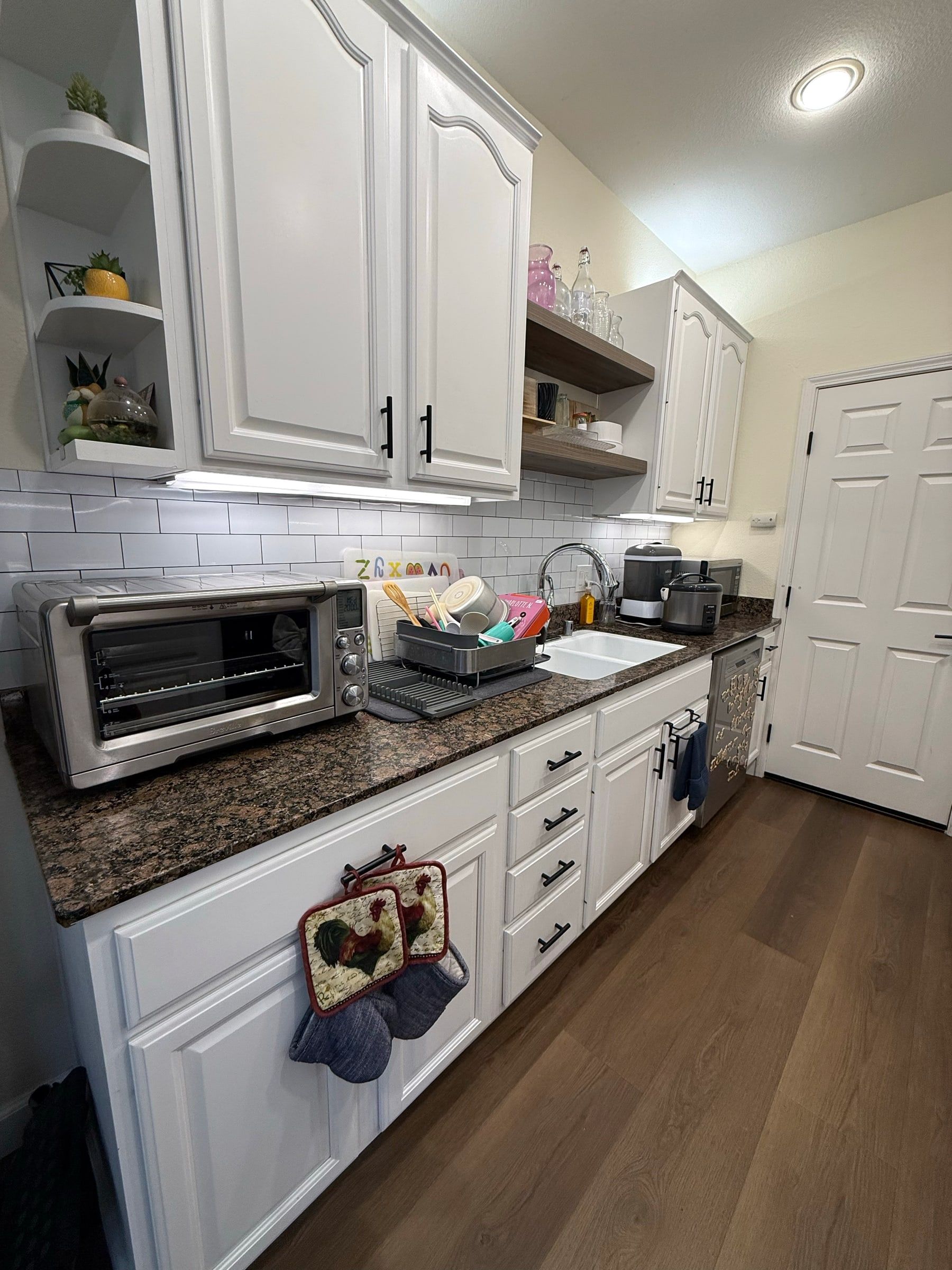 Bright white kitchen with tidy counters and gleaming wood floors