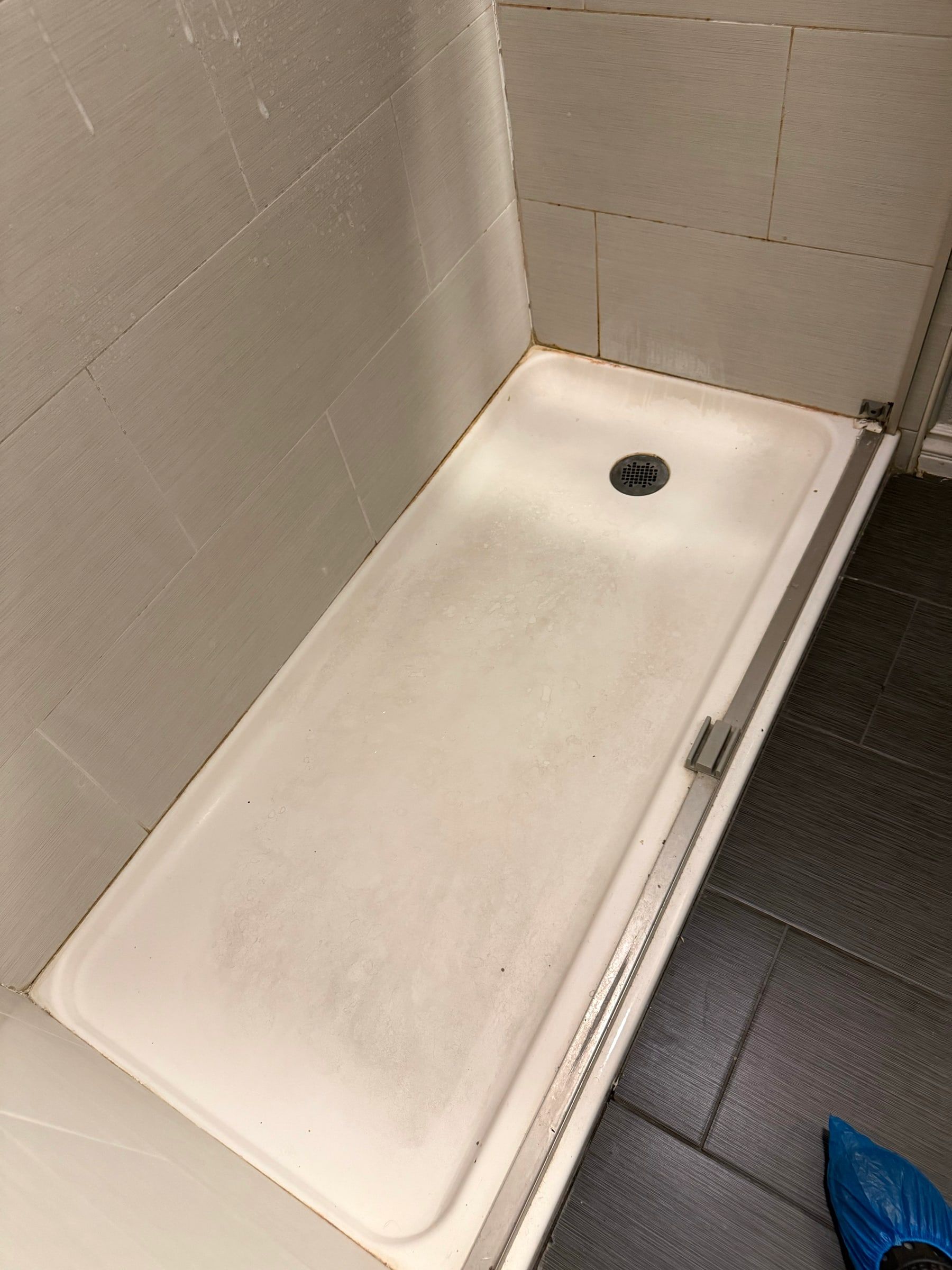 Before: Bathtub with a dull, stained surface before cleaning